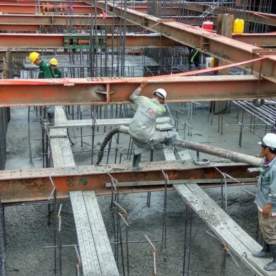 Workers are doing the concrete pouring for site foundation